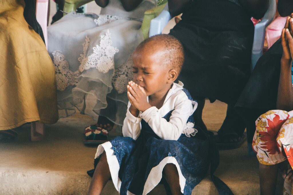 little black girl praying in the midst of adults, deepen your faith in difficult times