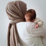 Hijabi woman carrying baby, mother mary carrying Jesus, Mary is our mother, veiled woman holding her baby,